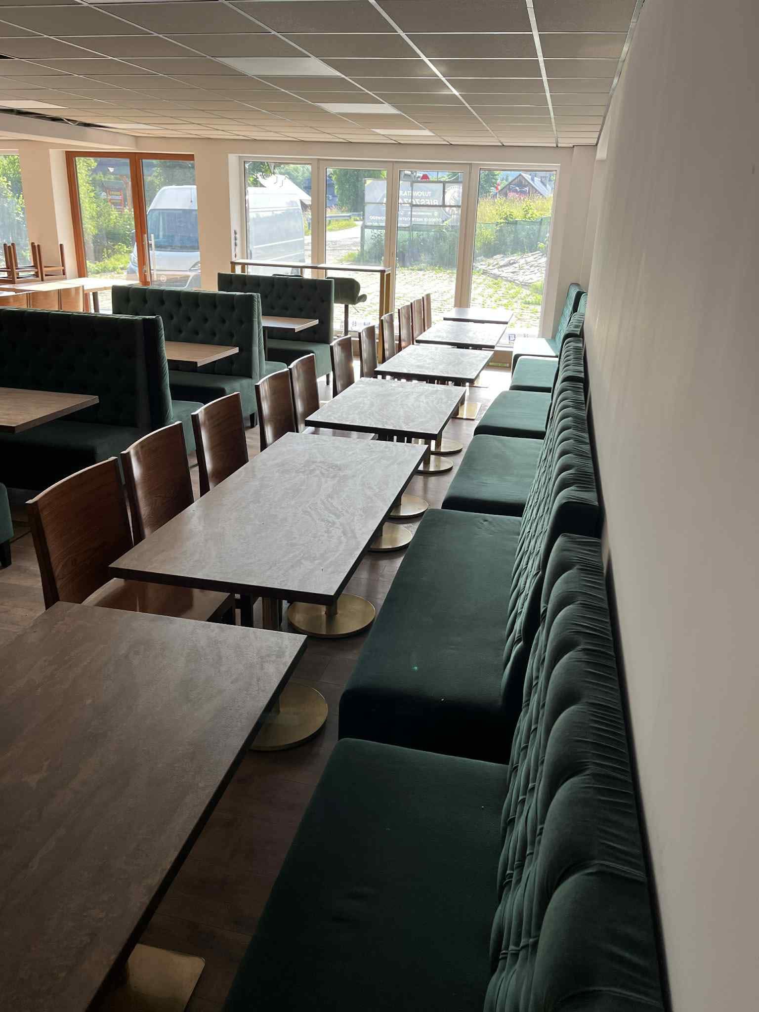Restauracja - stoliki z zielonymi siedziskami